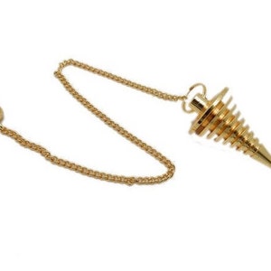 Może przedstawiać: Złoty wahadło z łańcuchem i stożkowym, spiralnie rowkowanym ciężarkiem. Łańcuch łączy się z małą, okrągłą kulką. Wahadło jest przeznaczone do wróżenia i praktyk duchowych.