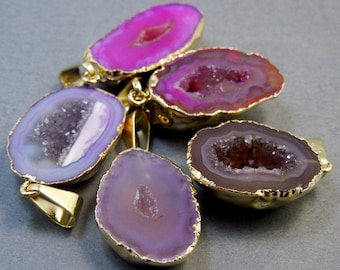 May include: Five agate pendants with gold trim. The agate is in shades of pink, purple, and brown. The agate has a natural crystal formation inside.