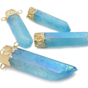 Op de afbeelding: Vier blauwe kristallen hanger met gouden accenten. Elke hanger heeft een gouden lus om aan een ketting of armband te bevestigen.