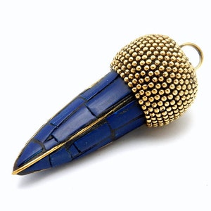 May include: A blue and gold pendant with a textured blue stone and a gold bead design. The pendant is shaped like a teardrop and has a loop at the top for attaching a chain.