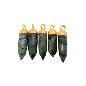 Puede incluir: Cinco colgantes de piedra preciosa verde y roja con tapas doradas. Los colgantes tienen forma de lágrima y un acabado rugoso y natural.