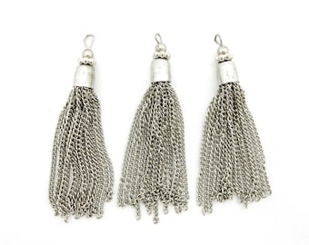 May include: Three silver chain tassels with a beaded top. The tassels are approximately 2 inches long.