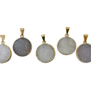 May include: Five gold-rimmed pendants with white and gray agate stone inserts. The pendants are round and have a smooth, polished finish.