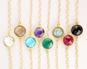 May include: Eight gold chain bracelets with different colored gemstone charms. The charms are round and faceted. The colors of the charms are clear, brown, purple, blue, green, gray, and red.