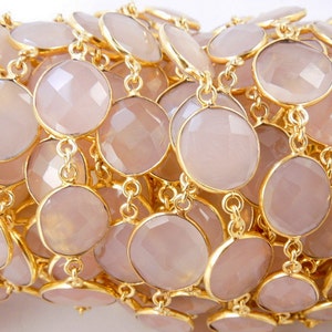 May include: A collection of Rose Pink Chalcedony Gold Plated Bezel Station Connector Chain Per Foot on white surface for reference.