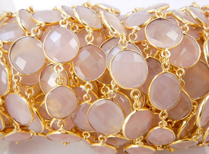 May include: A collection of Rose Pink Chalcedony Gold Plated Bezel Station Connector Chain Per Foot on white surface for reference.