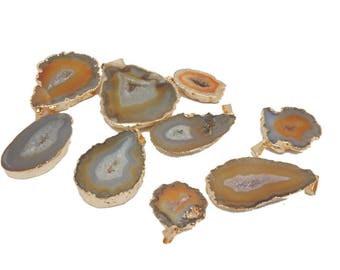 May include: A collection of eight agate slices with gold-toned edges. The agate slices are various shapes and sizes, with a mix of brown, orange, and white colors.