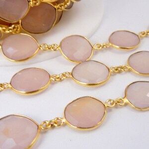 May include: A collection of Rose Pink Chalcedony Gold Plated Bezel Station Connector Chain Per Foot on white surface for reference.