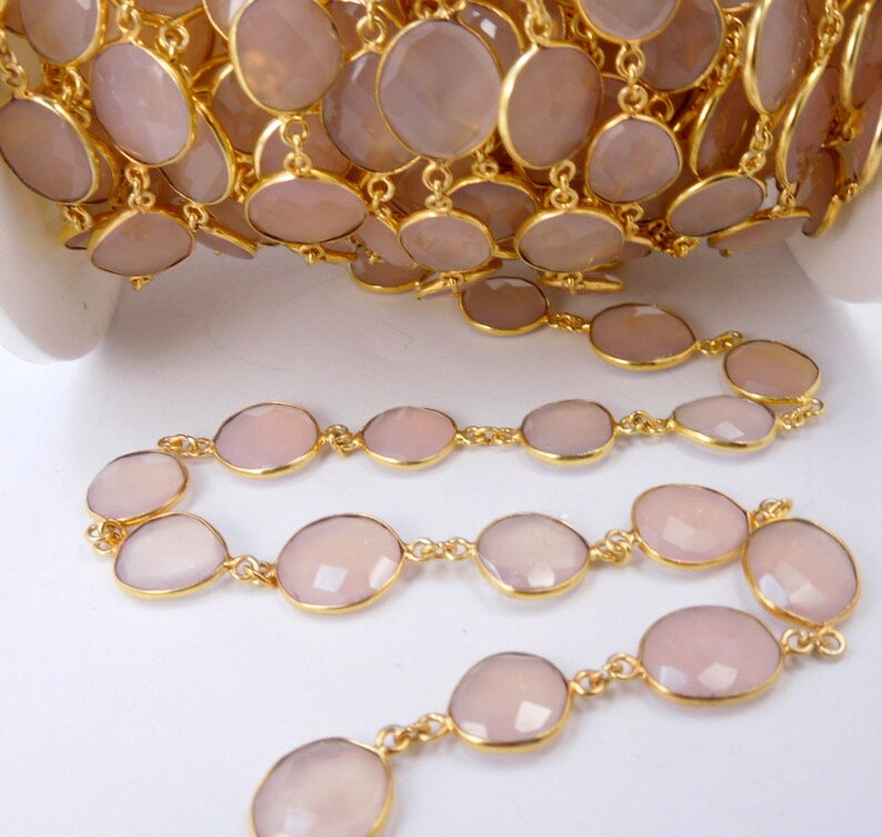 May include: A collection of Rose Pink Chalcedony Gold Plated Bezel Station Connector Chain Per Foot on white surface for reference.