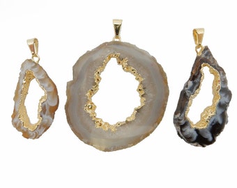 May include: Three agate pendant charms with gold-plated edges. The charms are in the shape of a teardrop with a hole in the center. The agate is a light brown color with white and black markings.