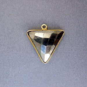 May include: A gold-toned triangle pendant with a faceted pyrite stone in the center.