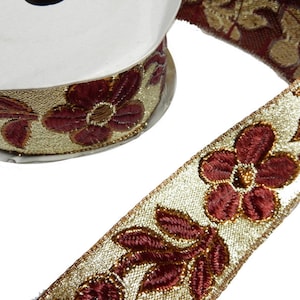 May include: Gold and burgundy trim with a floral design. The trim features a repeating pattern of stylized flowers and leaves.