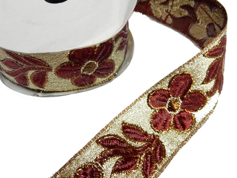 May include: Gold and burgundy trim with a floral design. The trim features a repeating pattern of stylized flowers and leaves.