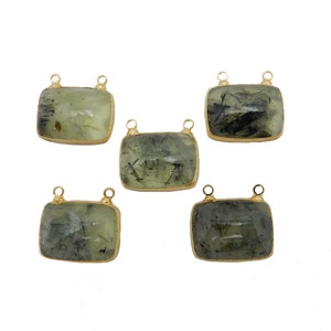 Op de afbeelding: Vijf goudkleurige metalen connectorstukken met groene en zwarte edelsteen inzetstukken. Elke connector heeft twee lussen om sieraden aan te bevestigen.