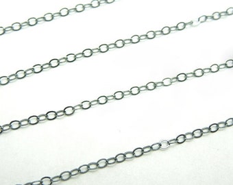 May include: A close-up of a black chain with round links. The chain is made of metal and has a smooth finish.