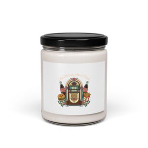 May include: A white candle jar with a black lid. The label features a retro diner design with a jukebox, soda bottles, a burger, and fries. The text on the label reads "Less Drama, More Fries."