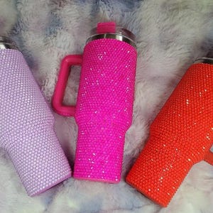 Pu&ograve; includere: Tre bicchieri isolanti ricoperti di strass scintillanti. I bicchieri sono nelle tonalit&agrave; lavanda, rosa acceso e arancione, ciascuno con manico e coperchio abbinati. I bicchieri sono progettati per mantenere le bevande fredde o calde.