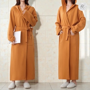 May include: A set of three ceramic mugs with a speckled, matte finish in cream, light grey, and dark grey. Each mug has a simple, minimalist design, suitable for coffee or tea.