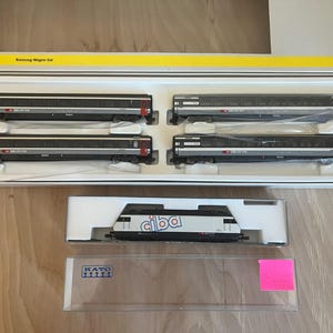 May include: A set of three ceramic nesting bowls in shades of blue, green, and white. The bowls feature a speckled glaze and a simple, modern design. The largest bowl measures approximately 8 inches in diameter.