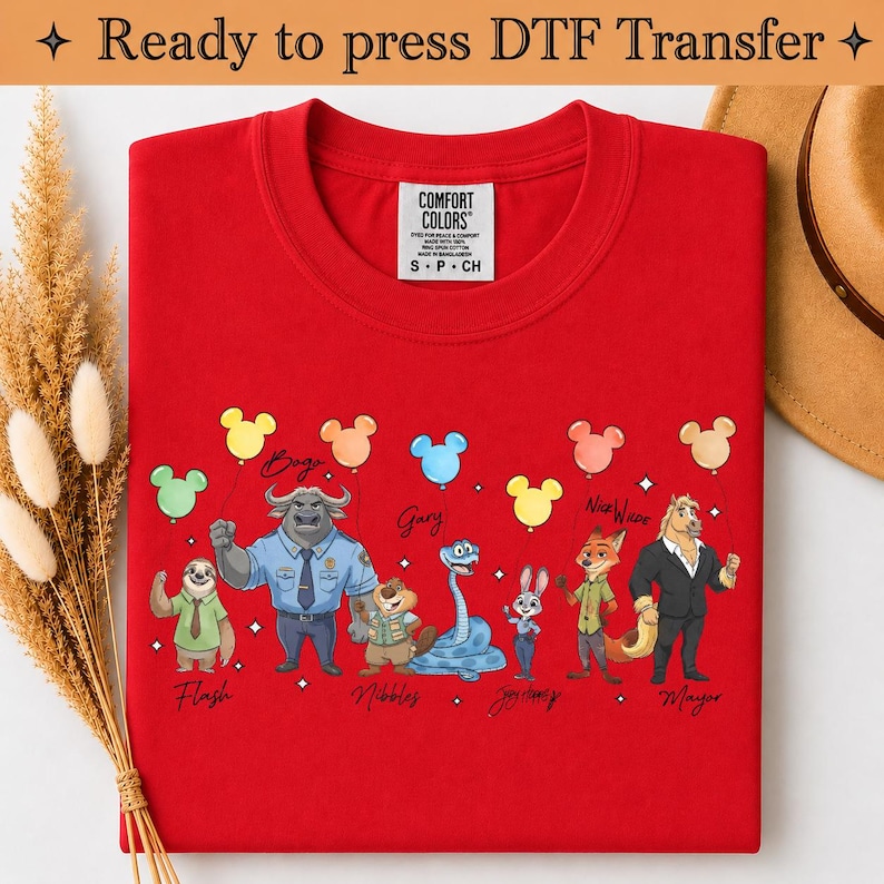 Puede incluir: Una camiseta de color rojo brillante con un estampado gr&aacute;fico de varios personajes animados de Zootopia, incluidos Flash, Bogo, Nibbles, Judy Hopps, Nick Wilde y el alcalde Lionheart, cada uno con un globo de colores, con el texto Ready to press DTF Transfer.