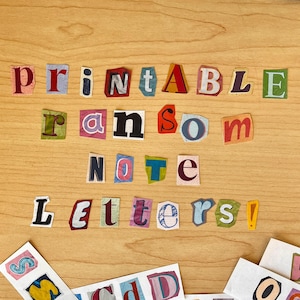 Puede incluir: Una superficie de madera muestra las palabras "Printable Ransom Note Letters!" recortadas de varias páginas de revistas coloridas. Las letras están dispuestas al estilo de una nota de rescate, con una estética lúdica y creativa.