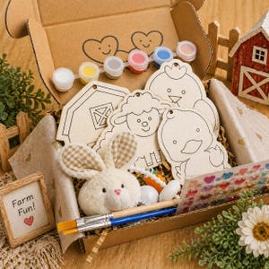 May include: A craft kit in a cardboard box containing wooden cutouts of a barn, sheep, and chick, a plush white bunny, paint pots, two paintbrushes, and a sheet of heart stickers. A small sign reads Farm Fun! with a red heart illustration.