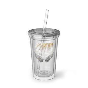 May include: Clear double-walled tumbler with a lid and straw. The tumbler features a design of gold glitter and white accents above a pair of silver wings. The tumbler is designed to hold cold beverages.