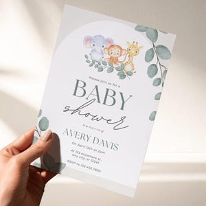 May include: A white baby shower invitation card featuring watercolor illustrations of a blue elephant, a brown monkey, and a yellow giraffe sitting on green eucalyptus leaves. The text reads: Please join us for a BABY shower honoring AVERY DAVIS.