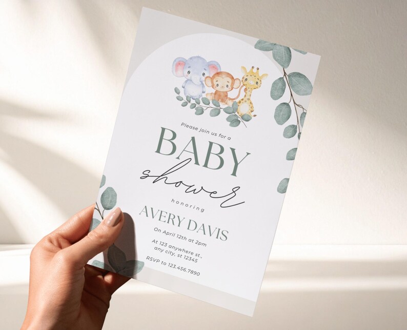 May include: A white baby shower invitation card featuring watercolor illustrations of a blue elephant, a brown monkey, and a yellow giraffe sitting on green eucalyptus leaves. The text reads: Please join us for a BABY shower honoring AVERY DAVIS.