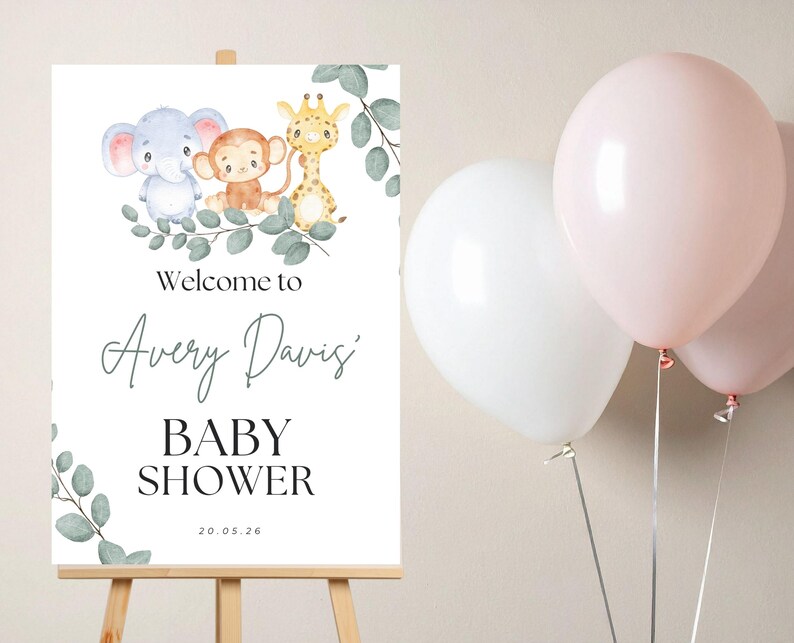 May include: A white rectangular sign on a wooden easel featuring watercolor illustrations of a blue elephant, a brown monkey, and a yellow giraffe surrounded by green eucalyptus leaves. The text reads Welcome to Avery Davis' BABY SHOWER 20.05.26.