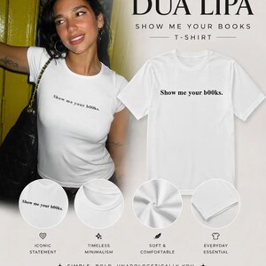 May include: A white short-sleeved t-shirt featuring the black text "Show me your b00ks." printed on the chest. The design includes a crew neckline and a standard fit. The shirt is displayed both on a person and as a flat product shot.