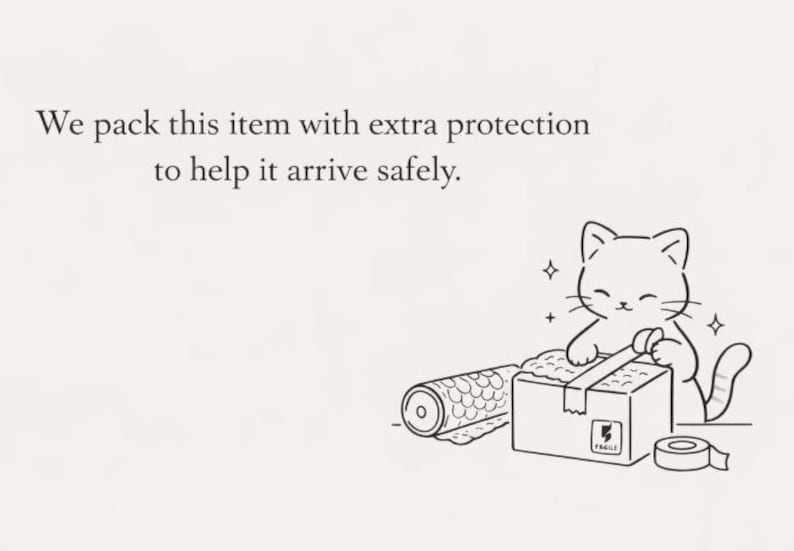 May include: A black and white line drawing of a cat taping a cardboard box with a roll of bubble wrap nearby. The text reads: We pack this item with extra protection to help it arrive safely. The box features a small label with the word FRAGILE.