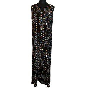 May include: Sleeveless black maxi dress with a repeating pattern of colorful clothing items. The dress has a scoop neckline and a long, flowing silhouette. The pattern includes shirts, pants, and other garments in various colors.