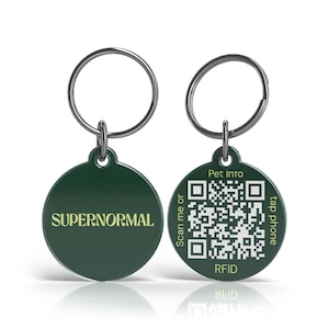 Può includere: Due targhette identificative per animali domestici verde scuro con portachiavi argentati. Un'etichetta ha la scritta "SUPERNORMAL" in un carattere giallo chiaro. L'altra etichetta ha un codice QR, le parole "Pet Info", "Scan me or", "tap phone" e "RFID".