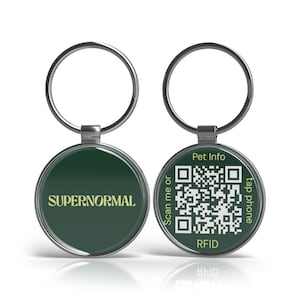 Puede incluir: Dos chapas de identificación redondas para mascotas, plateadas. Una chapa tiene la palabra "SUPERNORMAL" en amarillo sobre un fondo verde oscuro. La otra chapa tiene un código QR, las palabras "Pet Info", "Scan me or", "tap phone" y "RFID".