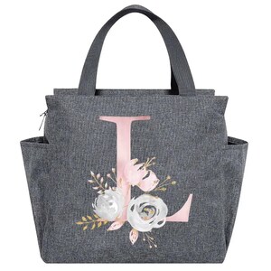 May include: Gray insulated lunch bag with a pink letter "L" and floral design. The bag has a top handle, side pockets, and a zipper closure. The floral design includes white and pink roses with gold accents.