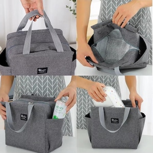 May include: A gray insulated lunch bag with a top handle and side pockets. The bag has a zippered main compartment and a silver insulated interior. The bag has a small black and white label that says "Bluskin".