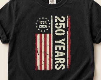 May include: Black t-shirt featuring a distressed American flag design with the text "250 YEARS" and the years "1776" and "2026". The flag has red and white stripes and a blue field with stars.