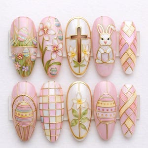 Unghie finte pasquali fatte a mano, con coniglietti rosa pastello, motivi floreali e decorazioni a forma di uova.