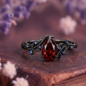 Bague en argent sterling ornée d'un rubis rouge taille poire et d'une feuille d'or noir.