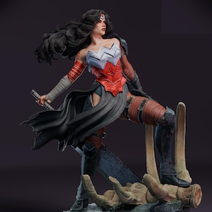 Puede incluir: Figura detallada de una guerrera en una pose dinámica, sosteniendo una espada. Viste un corpiño rojo y plateado, una capa negra y una armadura marrón y negra. La figura se encuentra sobre una base rocosa con estructuras óseas, con largo cabello negro.