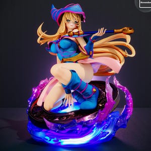 May include: A detailed figurine of a female character in a blue and pink outfit, holding a staff. The figure has long blonde hair and is kneeling on a base with blue and purple glowing accents. The word "November" is in the top right corner.