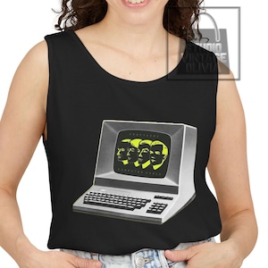 May include: A black sleeveless vest top featuring a graphic print of a vintage computer monitor. The screen displays four stylised yellow profiles of human heads and the text "KRAFTWERK COMPUTER WORLD" in a small, clear font on the monitor screen.