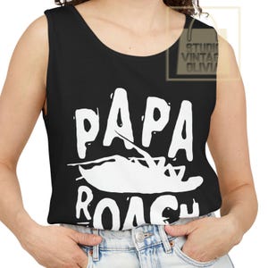 May include: Black tank top with the white text "PAPA ROACH" and a stylized insect graphic. The top is sleeveless and has a scoop neck. The text is in a bold, sans-serif font.
