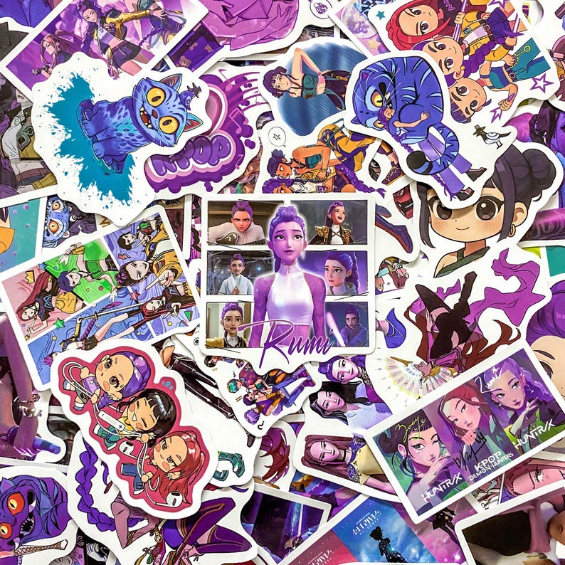 May include: A collection of assorted vinyl stickers featuring anime-style characters with purple hair, a blue cat-like creature, and text including Rumi, KPOP, and HUNTRUX. The stickers display various scenes, portraits, and graphic illustrations.