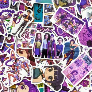 May include: A collection of assorted stickers featuring anime-style illustrations of characters with purple hair, musical themes, and K-pop inspired outfits. The designs include group portraits, individual character poses, and text reading K-POP DEMON HUNTERS.