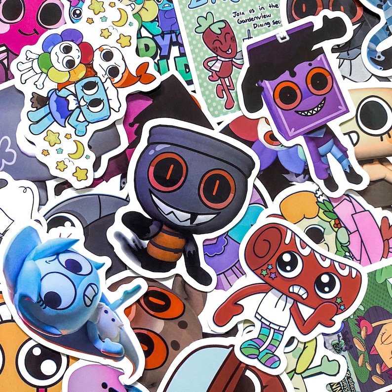 May include: A collection of assorted die-cut vinyl stickers featuring various cartoon characters with large eyes, including a purple square-headed figure, a dark grey creature with orange eyes, and a red cylindrical character with star accents.