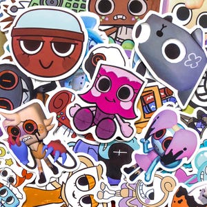 May include: A collection of assorted vinyl stickers featuring various cartoon characters with large eyes, including a red circular face, a pink figure, a grey creature, and a tan character with red eyes, all arranged in a dense, overlapping collage.