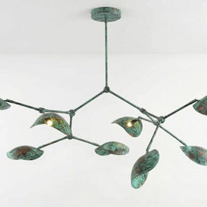 May include: A contemporary chandelier with a bronze finish. The light fitting has multiple leaf-shaped shades, each with a warm light. The design resembles a plant, with branches extending from a central stem. The overall dimensions are approximately 100 cm wide.