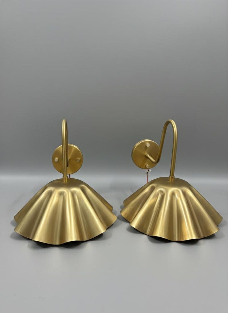 8-inch tall scalloped brass gooseneck wall sconces in a brushed satin finish, featuring 10-inch fluted shades and 5-inch round canopies projecting 15 inches from the wall.